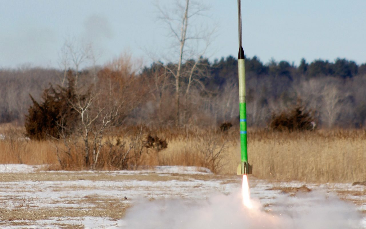 High power rocket lifting off from a snowy field